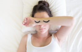 Painted sleeping eyes and Attractive brunette young woman in the white bed at morning time